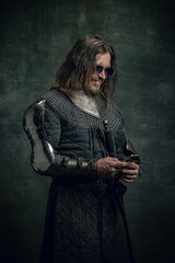 Vintage style portrait of brutal smiling man, medieval warrior or knight with dirty wounded face...