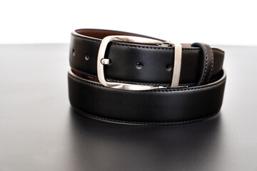  black leather belt on a black table. accessories store for men