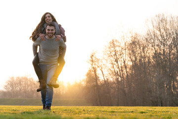 Young heterosexual couple walking and playing in a park on valentine's day