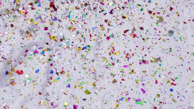 Beautiful colorful bright multicolor confetti and white snowy Christmas, Xmas or New Year celebration abstract 4k stock video background