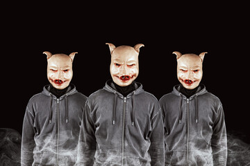 Group of anonymous criminals in hoodies wearing pig masks. Smoke and black background. Haters...