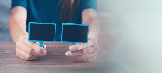young woman holding a small blank board