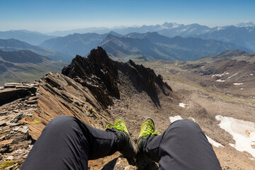 Fototapeta premium Mountains range panorama with legs and alpine boots in Italian alps, Stelvio National Park, Lombardy.