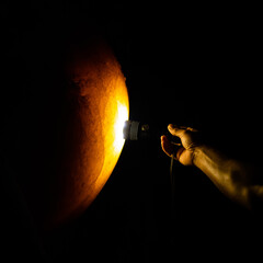 A man shines a torch at a rock in a cave. causing light to pass through the rocks