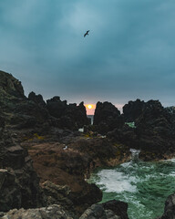 Naklejka premium sunset between beach rocks