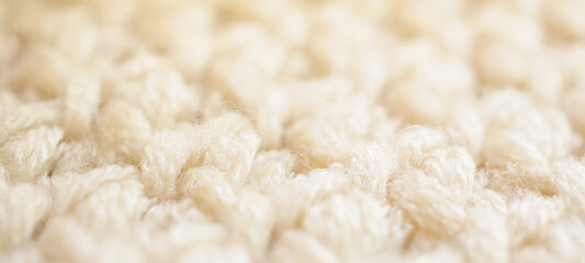closeup beige knitted woolen fabric texture background