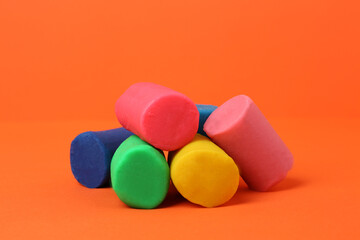 Different bright play dough on orange background