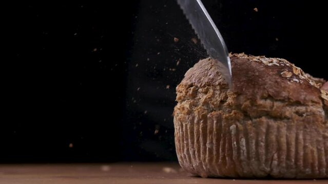 scattering bread crumbs while  bread being sliced slow motion.