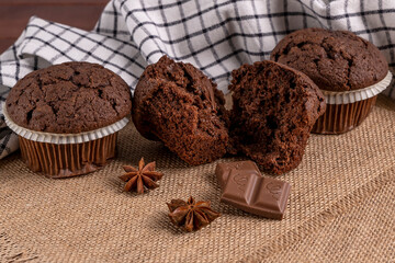 Delicious chocolate muffins with squared chocolate and star anise on jute mat