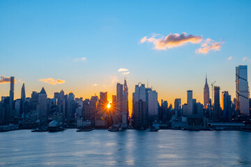 Fototapeta premium Stunning sunrise over Manhattan skyline with saturated colors and sun rays camping from the sun.