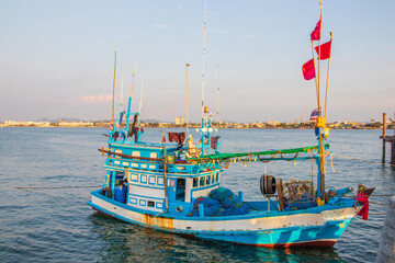 In the evening, colorful fishing boats are securely tied down directly at the pier with seaman's...