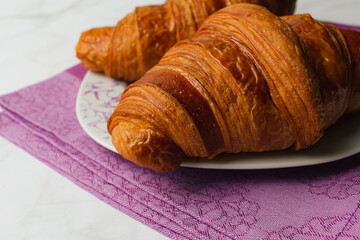Close up of croissants isolated over marble background. Delicious breakfast or snack with selective focus and copy space.