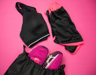 Womens gym wear. Sports bra, shorts for workout and training shoes in a black bag. Ladies fitness...