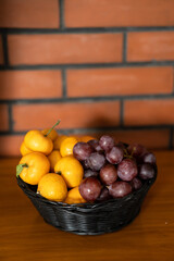 oranges and grapes on small basket