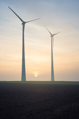 wind turbines in the wind at sunset