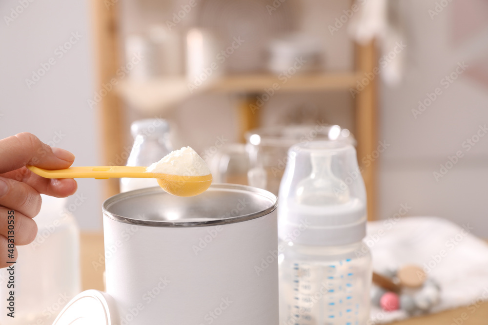 Wall mural woman preparing infant formula at table indoors, closeup. baby milk