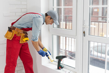 worker installing new plastic pvc window