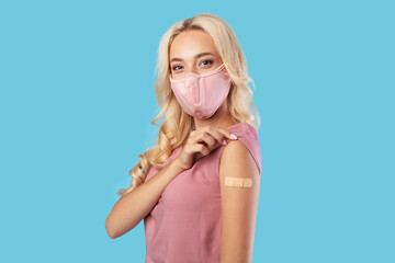 Happy Vaccinated Woman In Facemask Showing Arm With Adhesive Bandage - obrazy, fototapety, plakaty