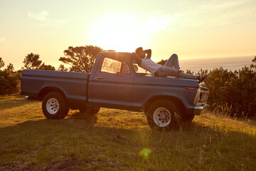 Do what your heart desires. Shot of a young man lying on the roof of his truck on a roadtrip. © Anne B/peopleimages.com
