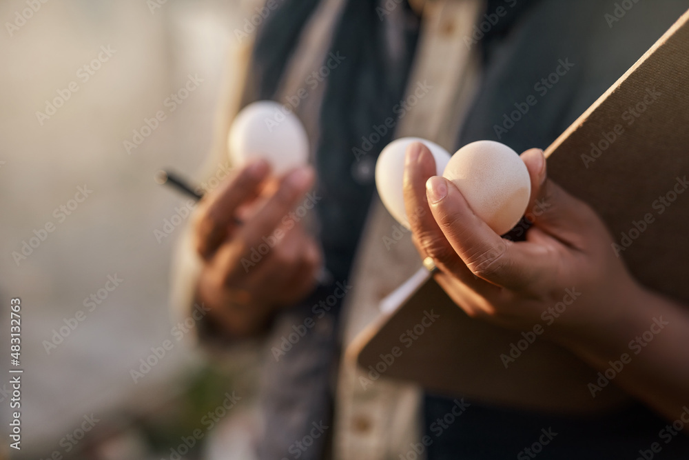 Poster all ready for distribution. shot of an unrecognisable farmer inspecting the quality of eggs on his f