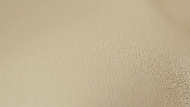 White leather close-up, luxury animal skin texture, classic fabric background, beige material.