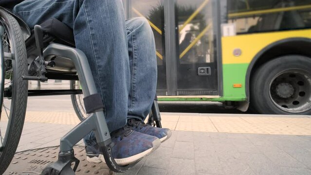 Person with a physical disability waiting for city transport with an accessible ramp