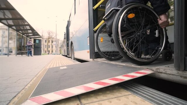 Person with a physical disability enters public transport with an accessible ramp