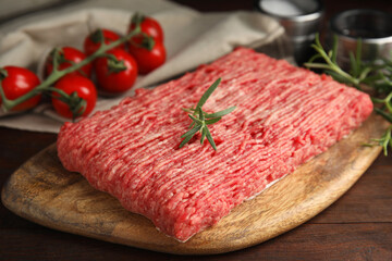 Board with raw fresh minced meat on wooden table