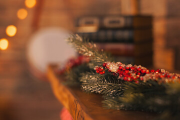 christmas decoration with fake fir and red berries on mantelpiece closeup