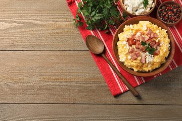 Delicious traditional Ukrainian banosh served on wooden table, top view. Space for text