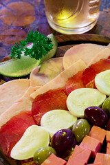 Detail of cold cuts board with hearts of palm, salami and olives