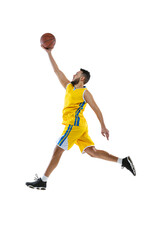 Dynamic portrait of professional basketball player jumping with ball isolated on white studio background. Sport, motion, activity, movement concepts.