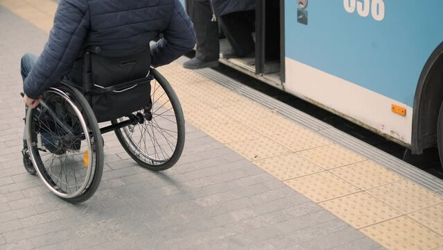 Person with a physical disability enters public transport with an accessible ramp