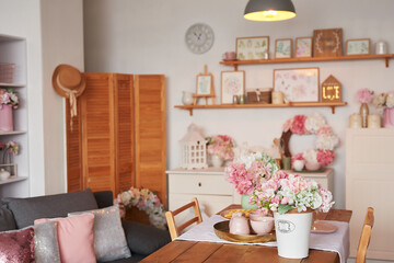 Pink living room and kitchen. Studio apartment. Loft interior. Shelves and spring decor in room. Rent and delivery of housing. Hostel and hotel.