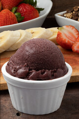 Açaí ball in a white bowl with fruits and granola. Selective focus.