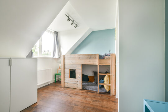 Mansard bedroom for children with wooden bunk bed