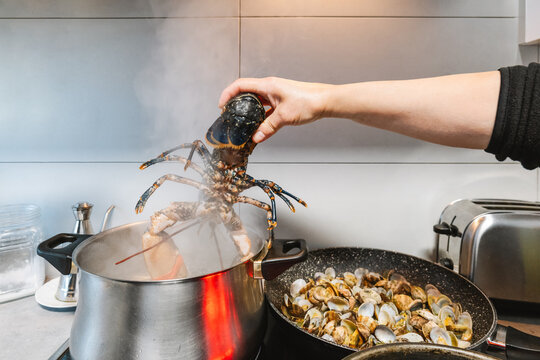 Faceless person putting lobster into pot