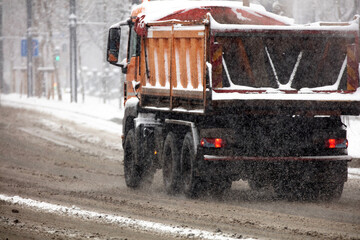 Snow plow truck cleaning streets from heavy snowfall.