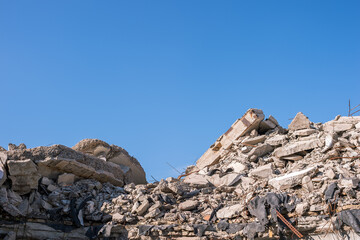 Piles of construction waste in the form of concrete fragments of slabs, piles, bricks on a...