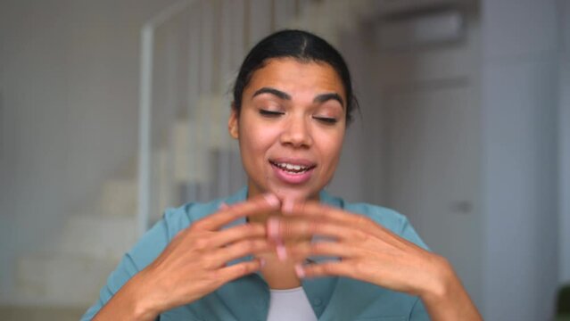 Webcam shot of young positive woman communicating via video communication using laptop, she gesturing in front of the screen. Self-isolation during quarantine. Video communication, video call