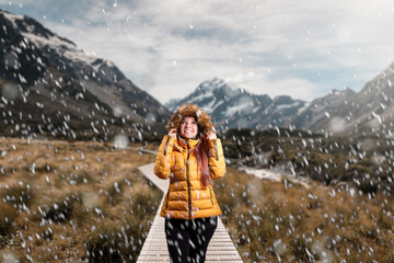 Mujer caminando durante caida de nieve en bosque patagónico
