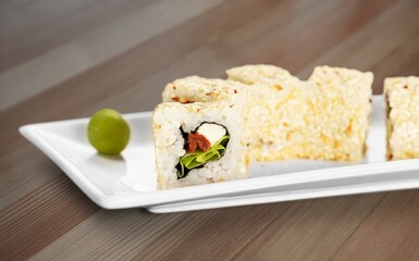 Warm sushi set on board with wassabi and soy sauce.