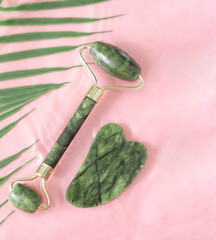 Jade facial roller for cosmetic facial massage, natural stone skin care products. It lay flat on a...