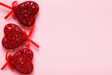 Red Valentine hearts on a pink background with space for text and copy space.