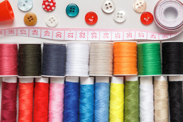 Multi-colored thread buttons measuring tape on a gray background.