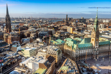 Obraz premium Panoramaaufnahme von Hamburg, mit dem Hamburger Rathaus mit blauem, leicht bewölktem Himmel, von oben aufgenommen