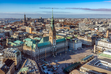 Obraz premium Panoramaaufnahme von Hamburg, mit dem Hamburger Rathaus mit blauem, leicht bewölktem Himmel, von oben aufgenommen
