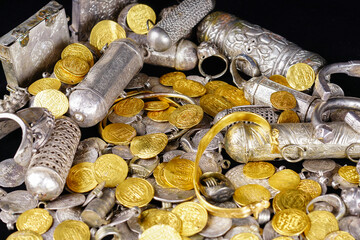 A lot of stacked gold bullion bars and gold coins and silver coins in a treasure sack. Treasure background. 
gold and silver jewelry. Ancient treasure. Pirate treasure and gold and silver filled crate