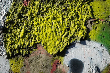 An old colorful concrete wall plastered with traces of old paint, texture.