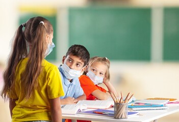 Fototapeta premium Group of children with face mask back at school after covid-19 and lockdown.
